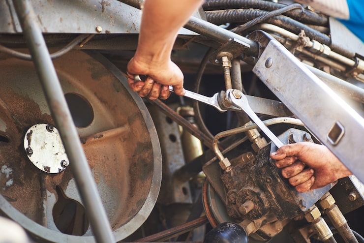 Mechanic using a spanner to service heavy plant machinery